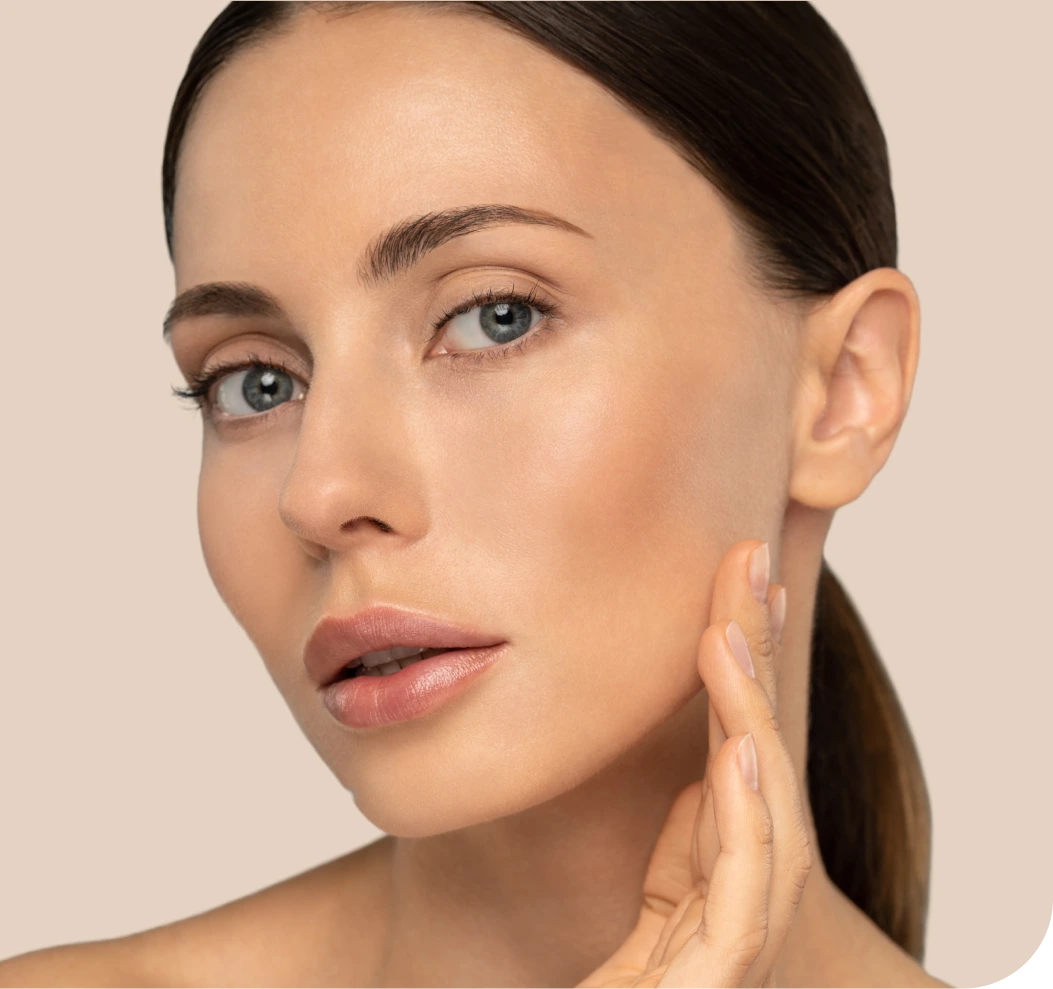 Woman touching her jawline in profile, demonstrating jawline filler results